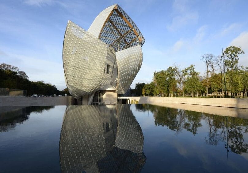 View of the Louis Vuitton Fondation designed by Canadian-American architect Frank Gehry in the Bois de Boulogne in Paris on October 17, 2014. The building which takes the form of a sailboat amongst the trees of the Bois de Boulogne, consists of twelve huge sails glass, and is part of the long tradition of architectural glass such as the Grand Palace. AFP PHOTO / BERTRAND GUAY